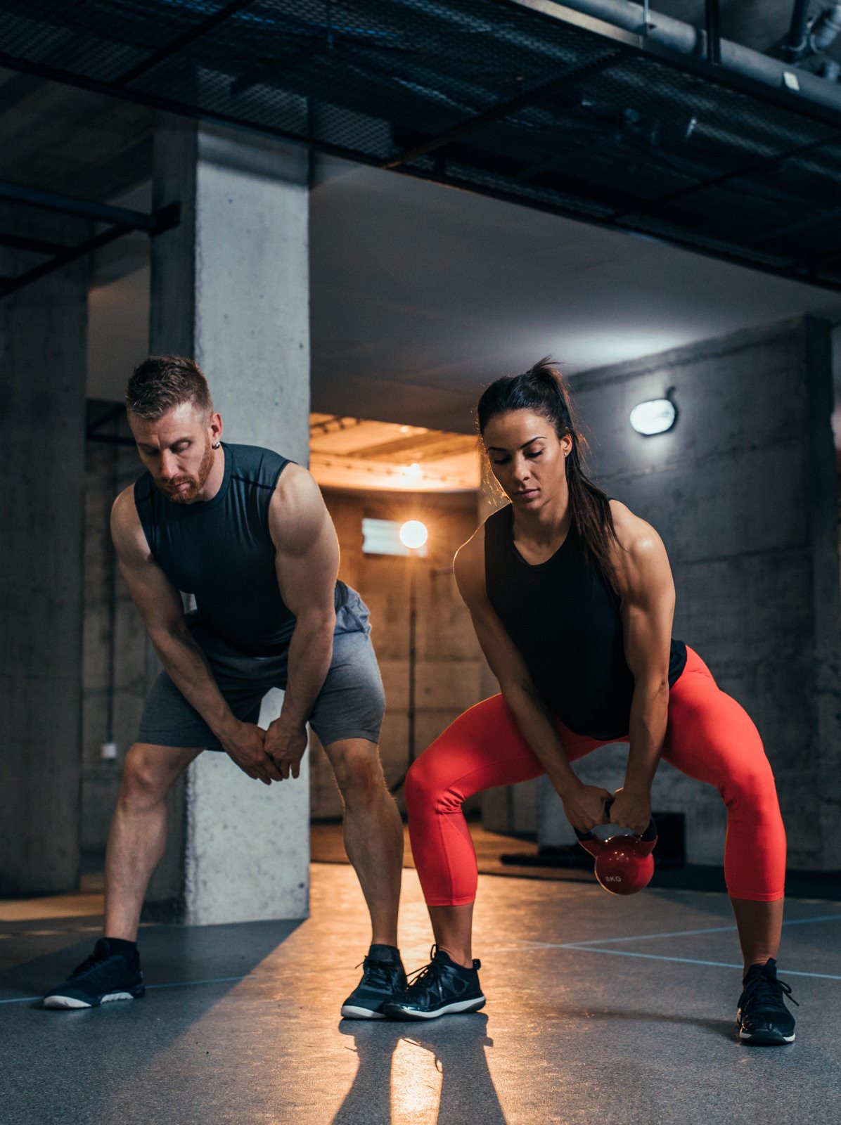personal trainer helping with kettle ball exercises
