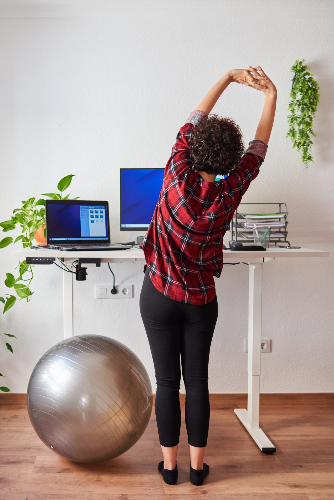 Woman stretchint next to her desk